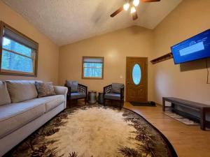 a living room with a couch and a flat screen tv at Maple Creek Cabin, minutes from Cook Forest, ANF in Marienville