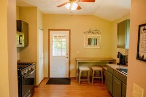 une cuisine avec des placards verts et une porte blanche. dans l'établissement Maple Creek Cabin, minutes from Cook Forest, ANF, à Marienville