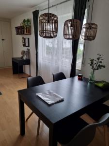 una mesa de comedor con sillas en una habitación con ventana en Ferienwohnung Appartement Bad Bergzabern mit Schwimmbad und Sauna, en Bad Bergzabern