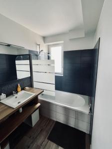 bagno con lavandino e vasca di Appartement - Concarneau a Concarneau