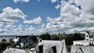 Blick auf eine Stadt mit Häusern und Wolken in der Unterkunft Appartement - Concarneau in Concarneau