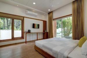 a bedroom with a large bed and a large window at Pakoid Cottages in Idukki