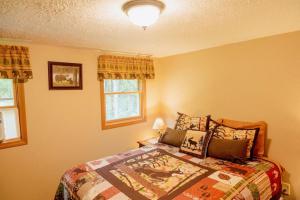 Marienville的住宿－Cozy Cottage near Cook Forest Park, ANF，一间卧室设有一张床和两个窗户。