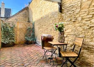 a patio with a table and chairs and a vase of flowers at China Cottage - Quaint, Cosy, Cotswolds Retreat in Charlbury
