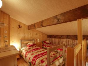 een slaapkamer met 2 bedden in een kamer met houten wanden bij Appartement Morillon Village, 3 pièces, 4 personnes - FR-1-642-54 in Morillon