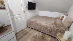 a small bedroom with a bed and a television at Apt FIONA1 Centrum700m Prywatny Parking Bezpłatny in Karpacz