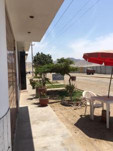 eine Terrasse mit einem Tisch, einem Tisch und Stühlen in der Unterkunft Hospedaje Los Lobos in Cerro Azul