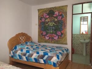ein Schlafzimmer mit einem Bett und einem Wandgemälde in der Unterkunft Hospedaje Los Lobos in Cerro Azul