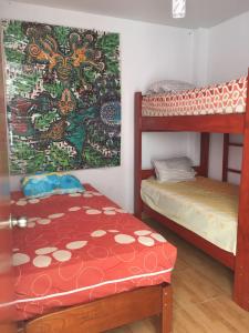 Zimmer mit 2 Etagenbetten und einem Tisch in der Unterkunft Hospedaje Los Lobos in Cerro Azul