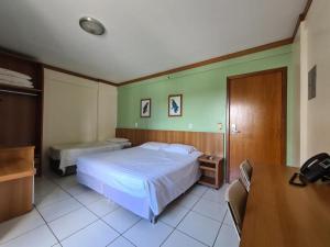 1 dormitorio con cama, escritorio y mesa en Flet Golden Dophin, en Caldas Novas
