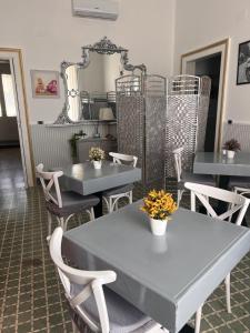 ein Esszimmer mit Tischen, Stühlen und einem Spiegel in der Unterkunft B&B Appia Antica in Massafra