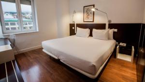 a bedroom with a large bed and a window at Exe Victoria Palace in San Lorenzo de El Escorial