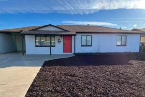 a house with a red door and a driveway at Stylish and Central Mesa Home with Private Pool! in Mesa