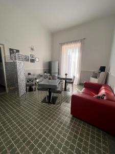 ein Wohnzimmer mit einem roten Sofa und Tischen in der Unterkunft B&B Appia Antica in Massafra