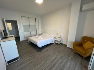 ein Schlafzimmer mit einem Bett, einem Stuhl und einem TV in der Unterkunft Luxury Port View R31 in Las Palmas de Gran Canaria