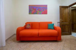 an orange couch in a room with a painting on the wall at IBibiena - SUITE BELLAVISTA in Bibbiena +38 photos