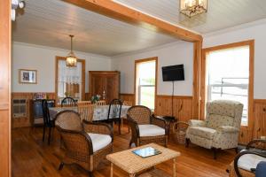 a living room with chairs and a table and a tv at Maison de Percé in Perce