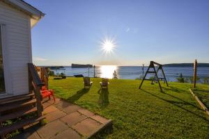 a view of a yard with a swing at Maison de Percé in Perce