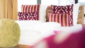 ein weißes Bett mit bunten Kissen und einer Couch in der Unterkunft Hotel Restaurant Krehl's Linde in Stuttgart