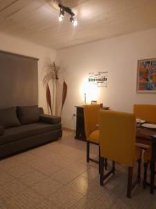 sala de estar con sofá, mesa y sillas amarillas en Alquiler Vacacional Belen Catamarca en Belén