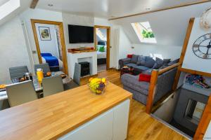 a kitchen and living room with a couch and a table at BISHOPS TAWTON SNOWDROP COTTAGE 3 Bedrooms in Bishops Tawton