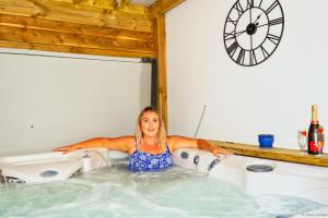 a woman is sitting in a hot tub at BISHOPS TAWTON SNOWDROP COTTAGE 3 Bedrooms in Bishops Tawton +39 photos