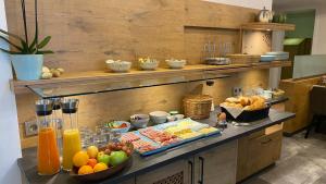 a breakfast buffet with fruit and drinks on a counter at Vico's Hotel & Restaurant Asperg in Asperg