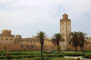 un bâtiment avec une tour d'horloge et des palmiers dans l'établissement Appartement Pour Couple et Famille, à Essaouira