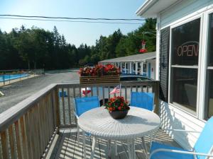 a table and chairs on a balcony with flowers at Belle Isle Motel in Bar Harbor