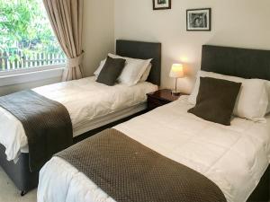 2 Betten in einem Zimmer mit Fenster in der Unterkunft Glen Mhor in Glenelg