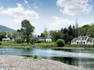 um rio com casas ao lado dele em Glen Mhor em Glenelg