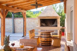 a patio with a pizza oven and a table with a wine barrel at Vacation villa Matic with 7 bedrooms in Sinj