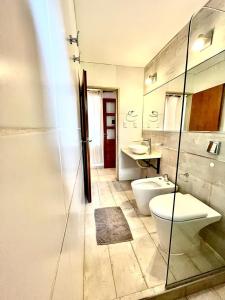 y baño con aseo, lavabo y espejo. en La Casita de Karen en Villa General Belgrano