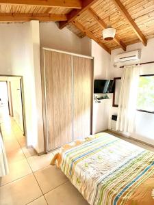 1 dormitorio con 1 cama grande y armario de madera en La Casita de Karen en Villa General Belgrano