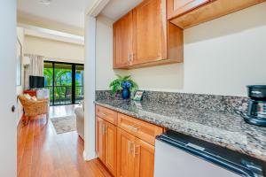 a kitchen with wooden cabinets and a counter top at Hanalei Bay Resort 2302 in Princeville