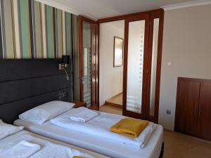 a bedroom with two beds and a mirror at Minaret Apartman in Eger