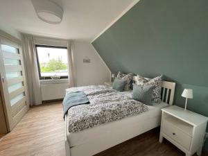 1 dormitorio con cama blanca y ventana en Ferienvermietung Strandnah en Großenbrode