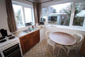 a kitchen with a table and a table and a sink at Crag End Farm Retreat, Rogerscale, Nr Cockermouth in Lorton