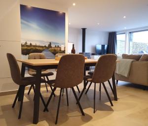 een eetkamer met een houten tafel en stoelen bij Aux 4 vents - Malmedy in Malmedy