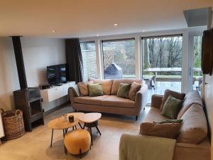 a living room with a couch and a table at Aux 4 vents - Malmedy in Malmedy