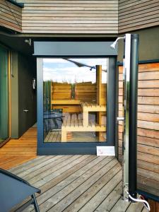 a screened in porch with a table and a deck at Seehaus LakeSide - Am Hafen in Neusiedl am See