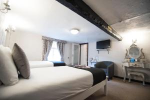 a bedroom with two beds and a desk and a window at The Pied Bull in Chester