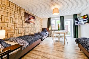 Zimmer mit 2 Betten und einem Tisch mit einem TV in der Unterkunft Adora Apartment Hilden in Hilden