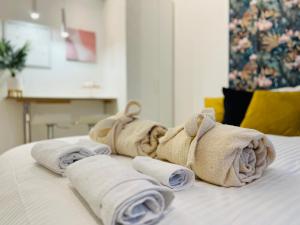 una pila de toallas sentadas encima de una cama en Suite del Ponte en Varese