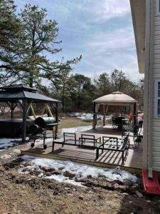 a wooden deck with a gazebo and a grill at Quiet Private House w Hot Tub/Fire pit/Games in Blakeslee