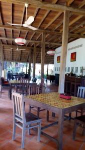 a large wooden table and chairs in a restaurant at Arun Mekong Guesthouse in Kratie