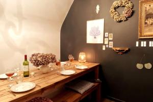 a wooden table with glasses and wine bottles on it at Grand appartement place Saint-Pierre, proche Château de Saumur et bord de Loire" in Saumur