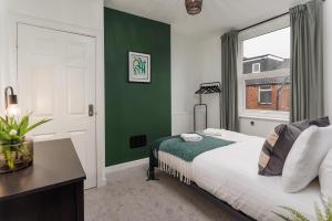 a bedroom with a bed and a green wall at Air Host and Stay - Talton House, sleeps 5, 7 minutes drive to city centre, free parking in Liverpool