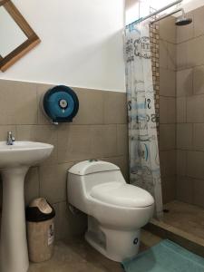 uma casa de banho com um WC e um lavatório em EL JARDIN OLON SUITES em Olón