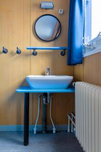 ein Badezimmer mit einem Waschbecken, einem Spiegel und einem Heizkörper in der Unterkunft ARCONA - Übernachten auf dem Wasser - direkt am Bontekai in Wilhelmshaven